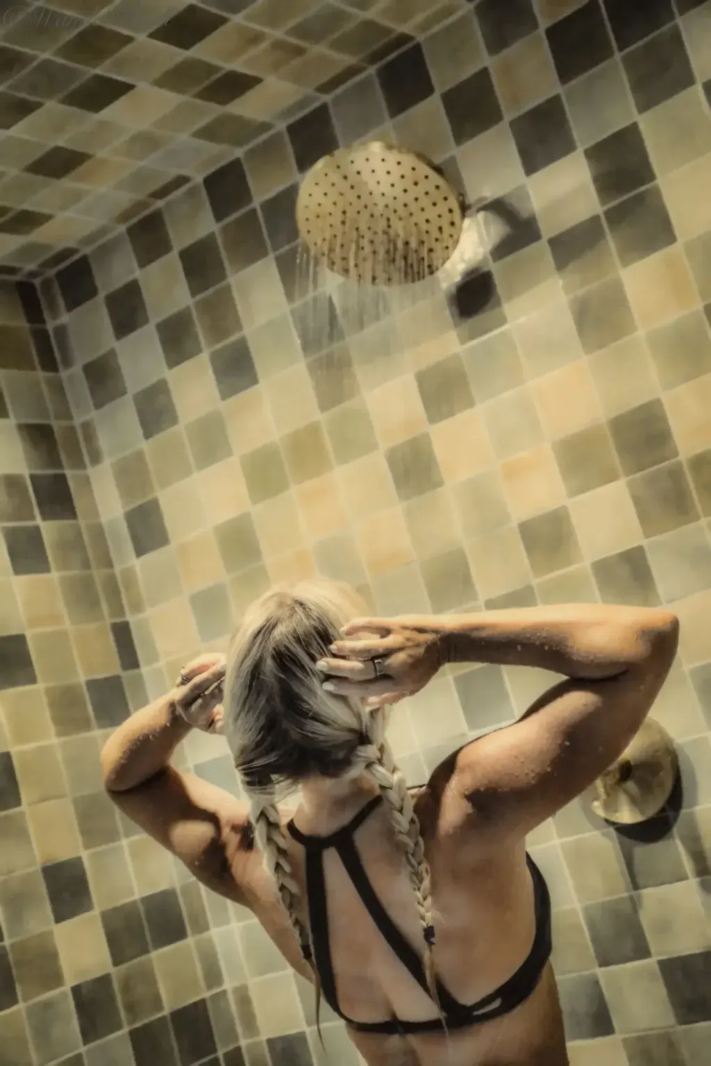 Rain showerhead in the tiled rinse area at Sauna Culture Charlotte — the post-sauna rinse station