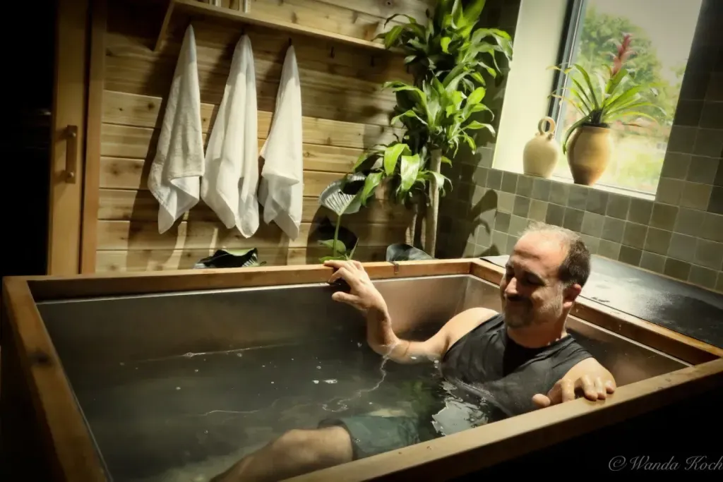Guest in a single wood-framed individual cold plunge at Sauna Culture in Cotswold, Charlotte