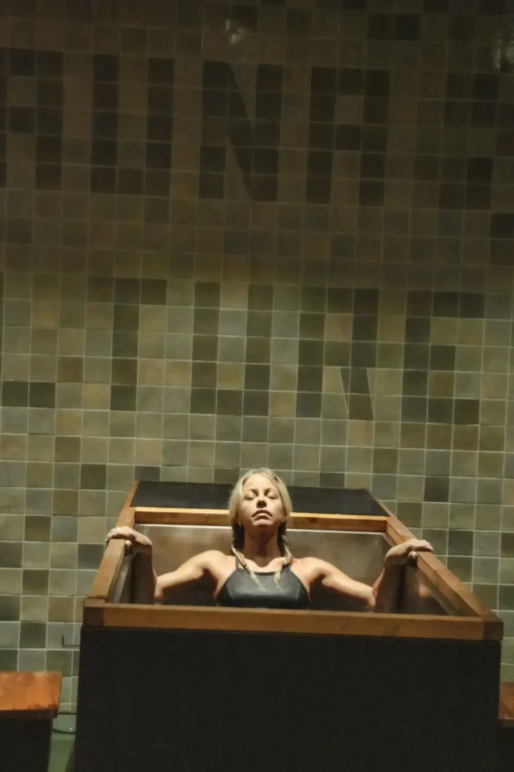 Single individual cold plunge framed against the Sauna Culture tile mural in Cotswold, Charlotte