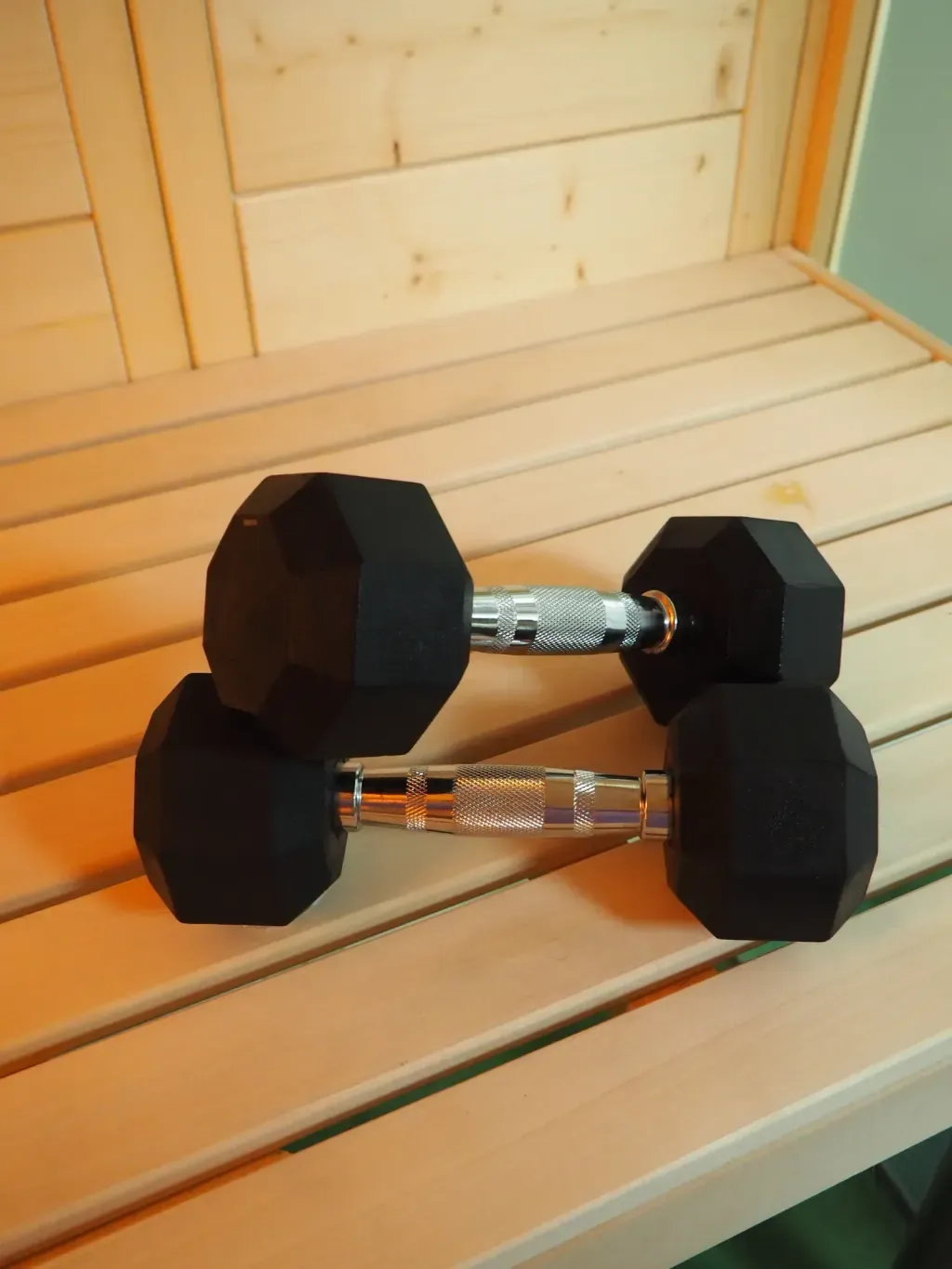 Athlete recovering with kettlebell beside the Finnish sauna stove at Sauna Culture Charlotte