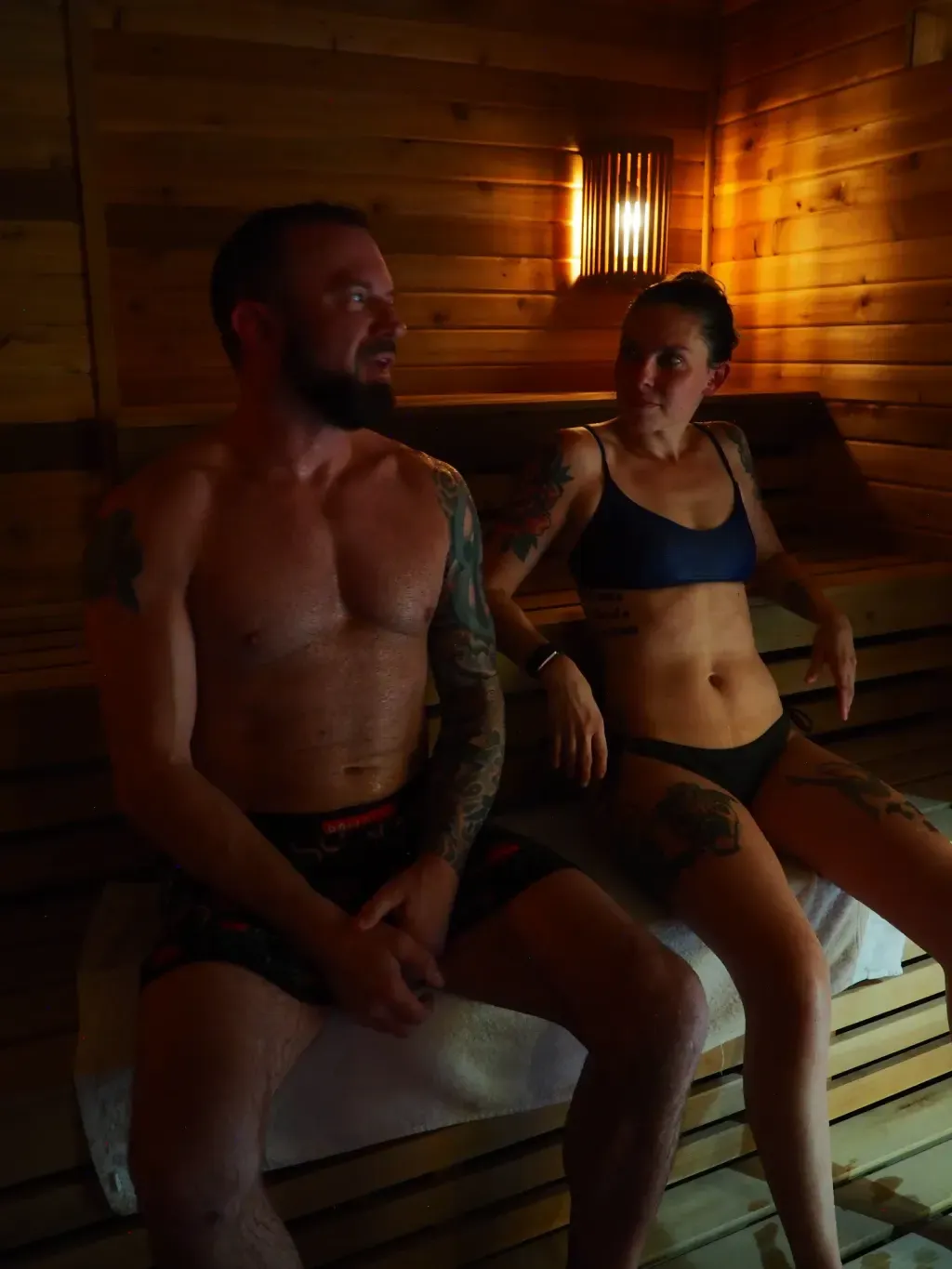Husband and wife sitting side by side in the Finnish sauna at Sauna Culture in Charlotte's Cotswold neighborhood