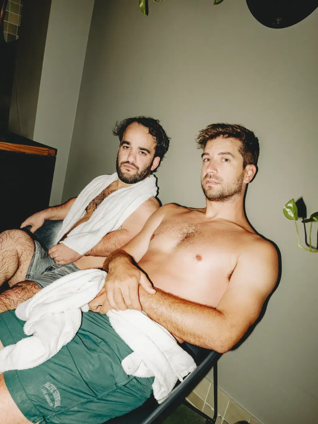 Two guests resting with towels on lounge chairs between rounds at Sauna Culture Charlotte