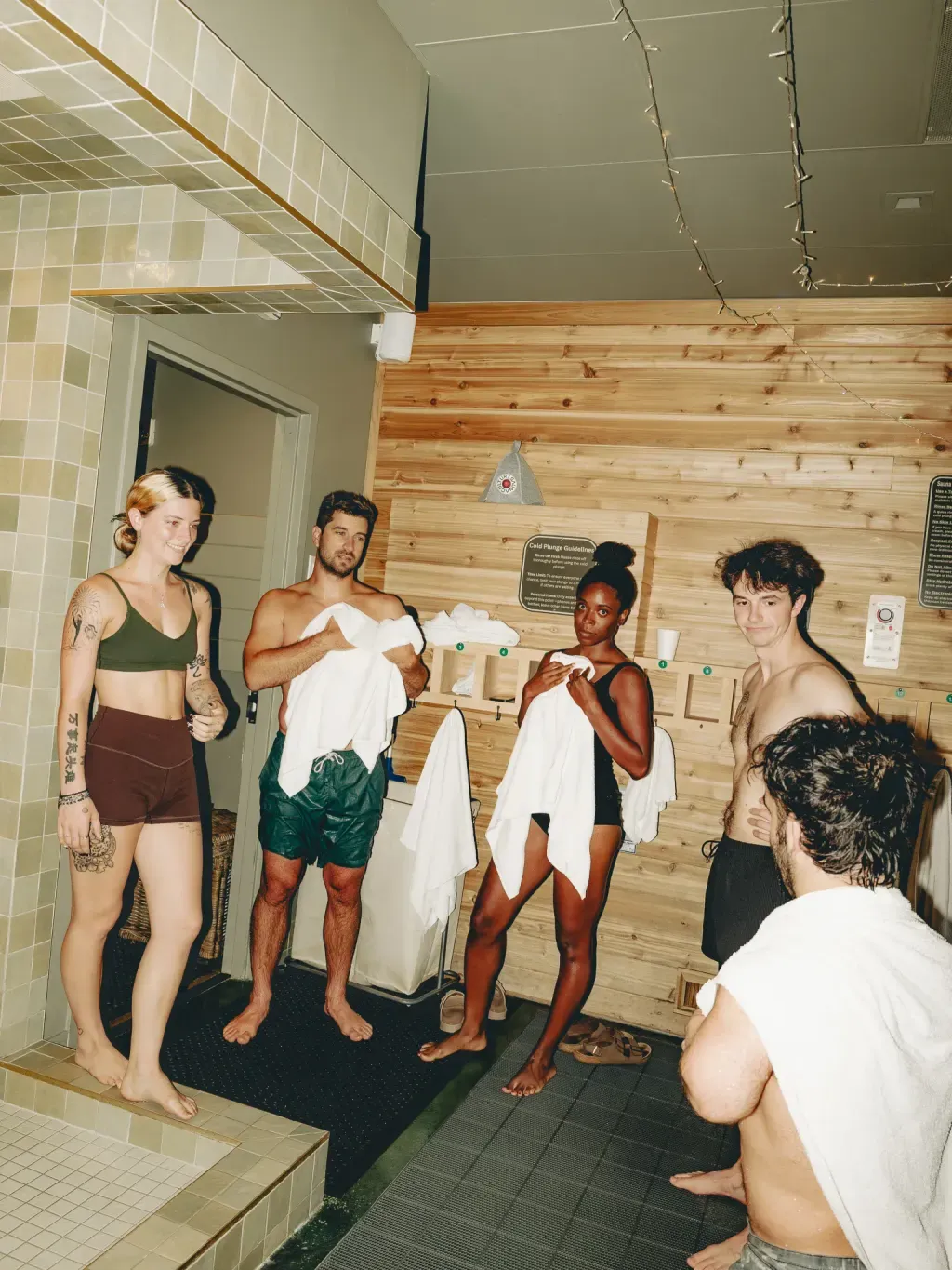 Five friends with towels in the changing alcove at Sauna Culture in Cotswold, Charlotte