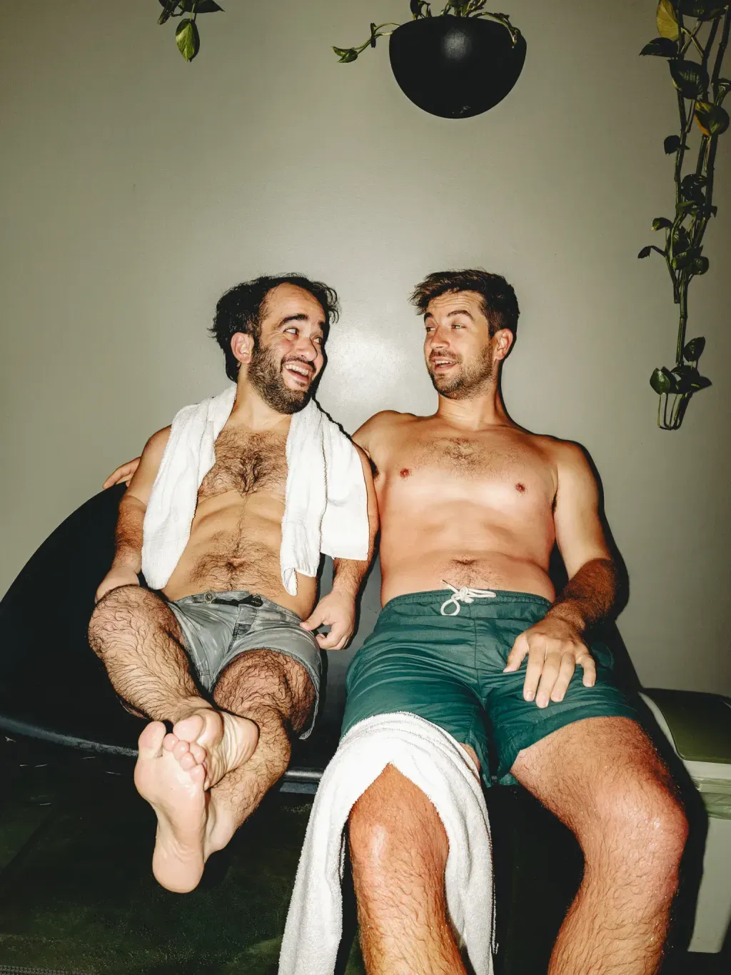 Two guests laughing on lounge chairs between sauna and plunge rounds at Sauna Culture Charlotte