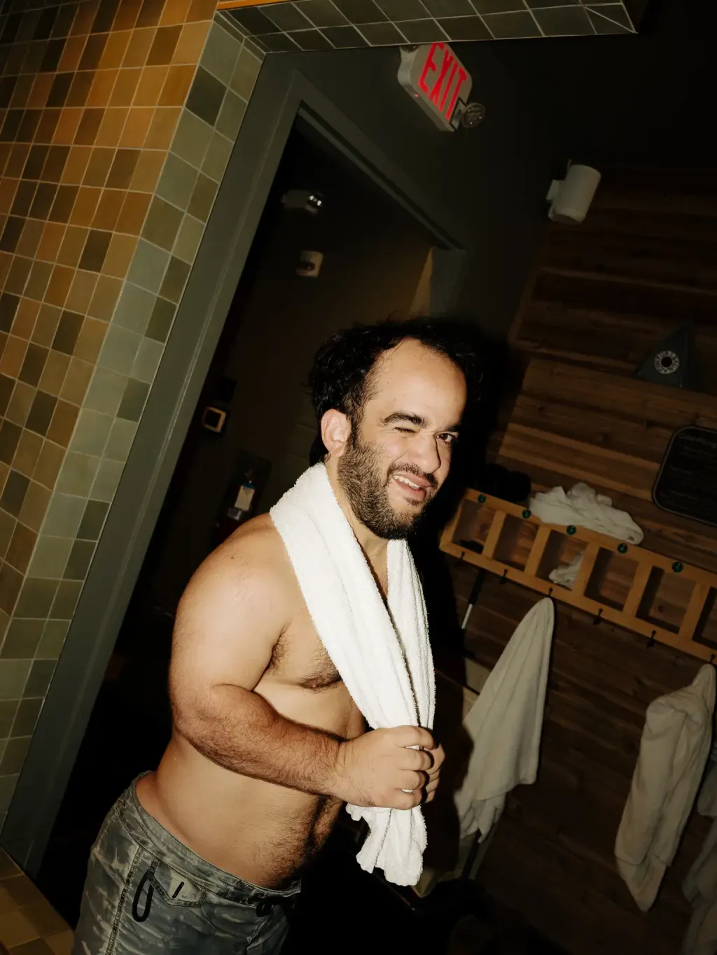 Guest winking with a towel in the changing alcove at Sauna Culture Charlotte