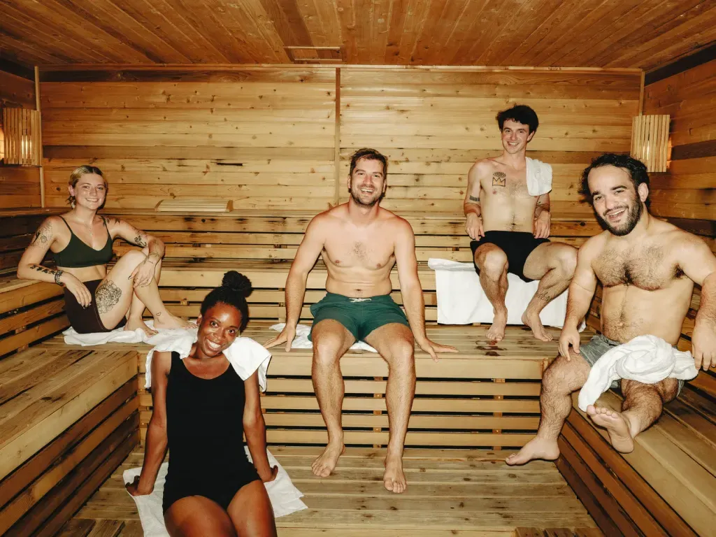 Five guests spread across the tiered cedar benches of the Finnish sauna at Sauna Culture Charlotte