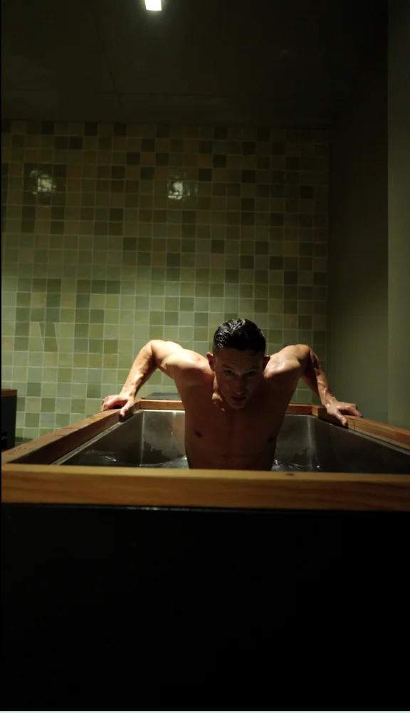 Guest rising from an individual cold plunge at Sauna Culture in Charlotte