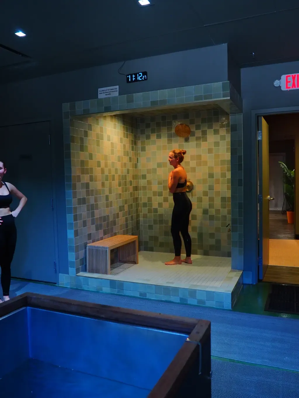 Guest rinsing under the shower between sauna and cold plunge rounds at Sauna Culture Charlotte